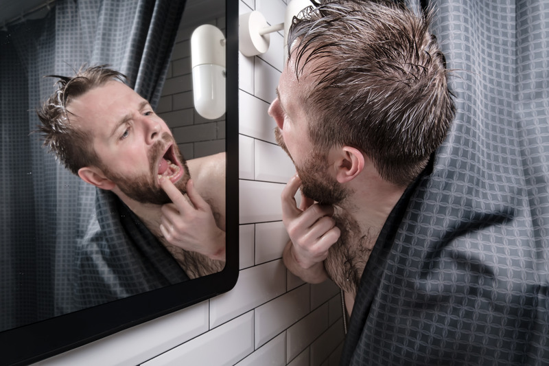 Patient looking at their wisdom teeth in a mirror