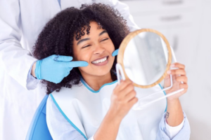 Woman smiling post root canal while dentist points out her teeth